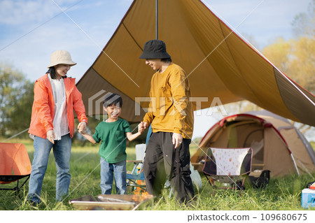 Smiling family holding hands and playing at the campsite Smiling family holding hands and playing at the campsite 109680675