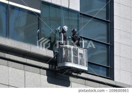 兩個人在纜車上清潔建築物窗戶 兩個人在纜車上清潔建築物窗戶 109680861