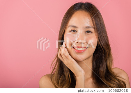 Eye skin treatment. Asian beautiful young woman smiling mask cosmetic patches gel under the eyes, Portrait female with natural makeup hydrogel eye patch on face, isolated on pink background, skincare 109682018