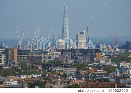 Scenic view of cityscape with blue sky in background. Skyscraper and cathedral amidst residential buildings in London. High angle view of modern development. 109682250
