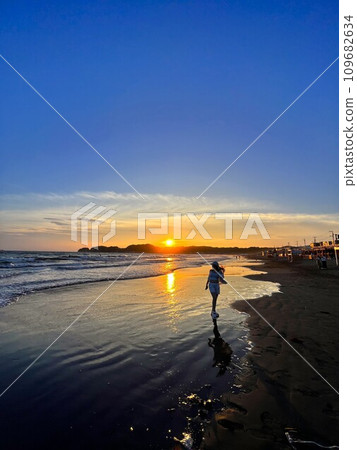 在黃昏時在沙灘上行走的女人 109682634