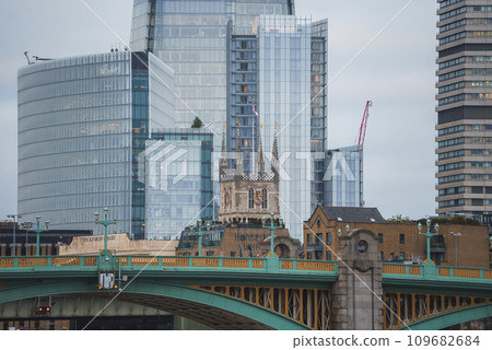 Southwark bridge and cathedral with apartments in background. Famous skyscraper The Shard in city of London. View of old and modern architectural beauty in downtown. 109682684