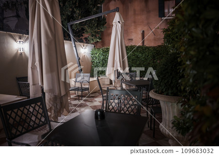 Experience a romantic and relaxing evening at an outdoor seating area in Venice, Italy. Enjoy dim lighting and soft music in this luxurious and elegant ambiance. Experience a romantic and relaxing evening at an outdoor seating area in Venice, Italy. Enjoy dim lighting and soft music in this luxurious and elegant ambiance. 109683032