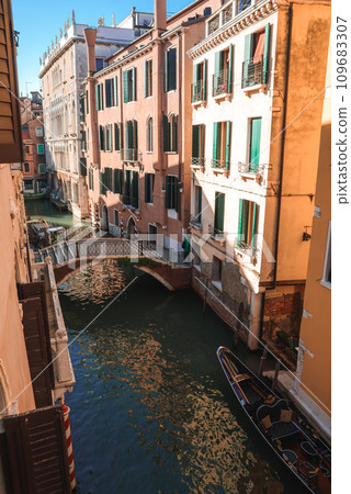 Experience the tranquil beauty of Venice with this serene view of a canal. The peaceful and quiet spot captures the essence of the city's canals during the summer. Experience the tranquil beauty of Venice with this serene view of a canal. The peaceful and quiet spot captures the essence of the city's canals during the summer. 109683307