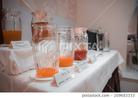 A refreshing assortment of orange, red, and yellow drinks in clear glass jars with white lids. Includes orange juice, lemonade, and iced tea. Perfect for a Venetian hotel or restaurant. A refreshing assortment of orange, red, and yellow drinks in clear glass jars with white lids. Includes orange juice, lemonade, and iced tea. Perfect for a Venetian hotel or restaurant. 109683333