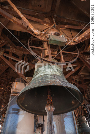 A large bell hangs inside a building in Venice, Italy. The interior is simple with no specific decor. The architectural style and material of the bell are not specified. A large bell hangs inside a building in Venice, Italy. The interior is simple with no specific decor. The architectural style and material of the bell are not specified. 109683391