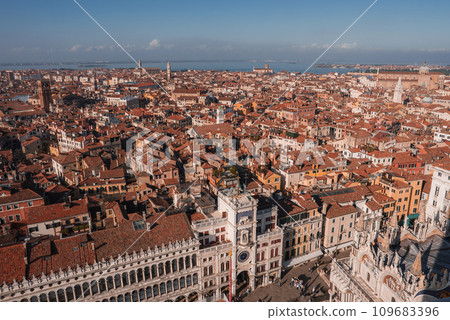 Aerial view of Venice, Italy, showcasing red-roofed buildings, gondolas, and intricate network of canals. Captures the charm and beauty of the iconic city from a unique perspective. Aerial view of Venice, Italy, showcasing red-roofed buildings, gondolas, and intricate network of canals. Captures the charm and beauty of the iconic city from a unique perspective. 109683396