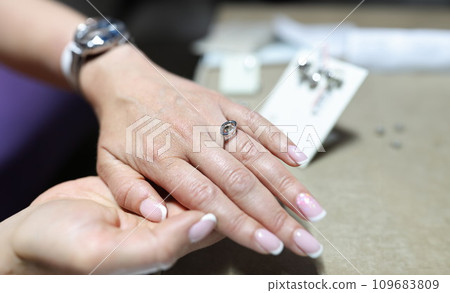 Woman choosing silver ring in jewelry store closeup 109683809