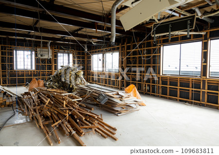 A demolished abandoned house piled with scrap materials 109683811