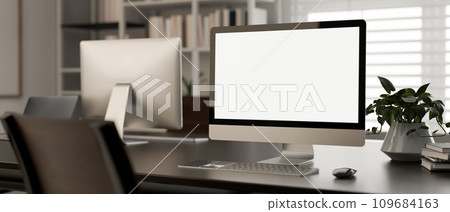 A white-screen PC computer mockup on a desk in a modern office room. workspace close-up image. 109684163