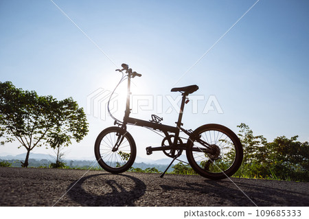 A folding bike on sunrise mountain top road A folding bike on sunrise mountain top road 109685333