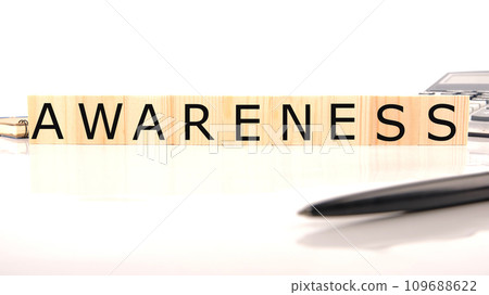 AWARENESS word word assembled from wooden cubes next to a calculator, pen and notepad AWARENESS word word assembled from wooden cubes next to a calculator, pen and notepad 109688622