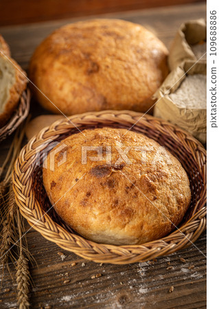 Whole fresh bread in wicker basket 109688886