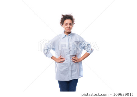 charming young brunette curly business woman in a blue shirt on a white background with copy space 109689015