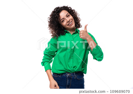 young caucasian lady with black curls dressed in a green blouse posing against a white background 109689070
