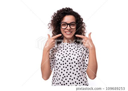 young caucasian businesswoman with curly hair dressed in a blouse with polka dots on a white 109689253