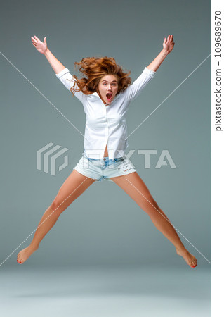 Beautiful jumping girl isolated on blue background 109689670