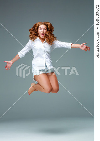Beautiful jumping girl isolated on blue background 109689672