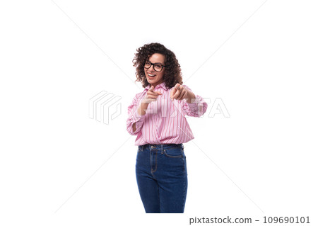 young pretty lady with curly black hair in a pink blouse and jeans on a white background with copy 109690101