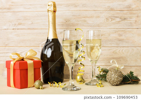 Champagne bottle with confetti, glasses and christmas decor on colored holiday background. Flat lay New Year decorations 109690453