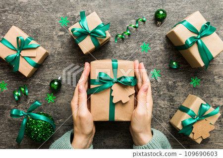 Woman hands holding gift box, preparing surprise for holiday, top view, Christmas and New Year concept Woman hands holding gift box, preparing surprise for holiday, top view, Christmas and New Year concept 109690603