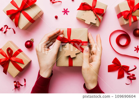 Woman hands holding gift box, preparing surprise for holiday, top view, Christmas and New Year concept Woman hands holding gift box, preparing surprise for holiday, top view, Christmas and New Year concept 109690604