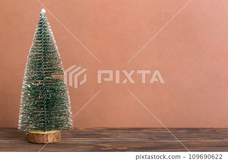 One small Christmas tree on colored background. new year decoration with copy space One small Christmas tree on colored background. new year decoration with copy space 109690622