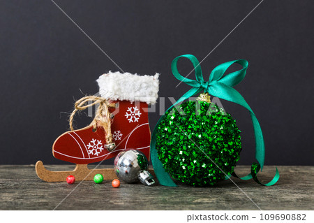 Christmas ball with skates on colored background. decoration bauble with ribbon bow with copy space 109690882