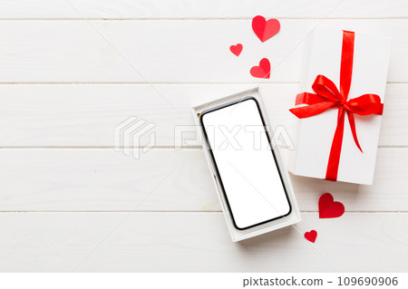 Opened gift box with ribbon and phone on color background, top view. Blank open box packaging mockup , Template for your design - branding mockup Opened gift box with ribbon and phone on color background, top view. Blank open box packaging mockup , Template for your design - branding mockup 109690906