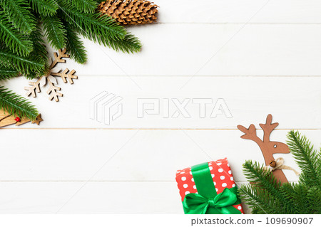 Top view of Christmas background made of fir tree branches and holiday decorations. New year concept with copy space on wooden background Top view of Christmas background made of fir tree branches and holiday decorations. New year concept with copy space on wooden background 109690907