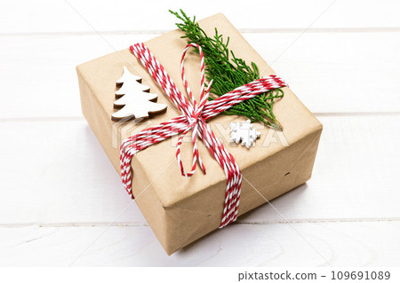 Christmas gift box wrapped in recycled paper, with ribbon top view with copy space on rustic background. Holiday concept Christmas gift box wrapped in recycled paper, with ribbon top view with copy space on rustic background. Holiday concept 109691089