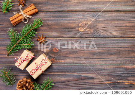 Christmas background with fir tree and gift box on wooden table. Top view with copy space for your design 109691090