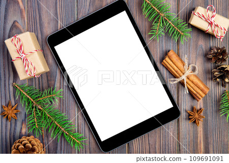 Digital tablet mock up with rustic Christmas wooden background decorations for app presentation. top view with copy space Digital tablet mock up with rustic Christmas wooden background decorations for app presentation. top view with copy space 109691091
