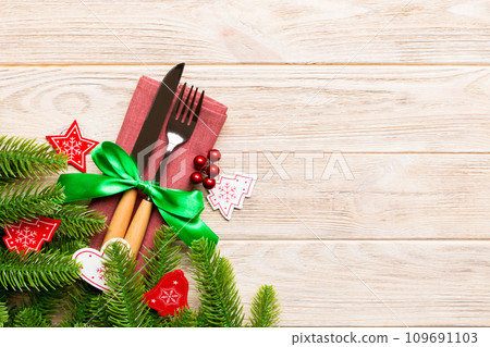 Top view of festive cutlery on new year wooden background. Christmas decorations with empty space for your design. Holiday dinner concept 109691103