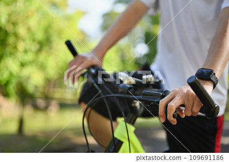Happy retired man riding bicycle in the public park. Health care and wellbeing concept Happy retired man riding bicycle in the public park. Health care and wellbeing concept 109691186