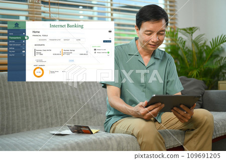 Satisfied middle age man sitting on couch and using easy online banking service at home 109691205