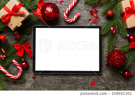 Top view of empty tablet on Christmas background made of new year decorand festive decorations. New year holiday concept. Mockup Top view of empty tablet on Christmas background made of new year decorand festive decorations. New year holiday concept. Mockup 109691302