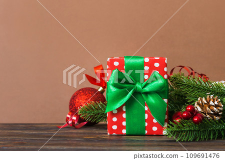 New Year Christmas mood, gift box, branches of a christmas tree, New Year decorations on a colored background New Year Christmas mood, gift box, branches of a christmas tree, New Year decorations on a colored background 109691476