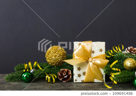 New Year Christmas mood, gift box, branches of a christmas tree, New Year decorations on a colored background 109691486