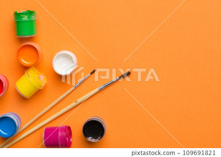art palette with paint and brushes, close up. Top view with empty space. workplace for creativity. home teaching concept drawing 109691821