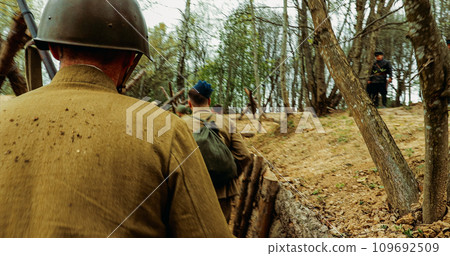 Reconstruction Of Battles World War Ii. Re-enactors Dressed As Soviet Russian Soldiers Take Up Fighting Positions In Trenches. Position Defense. Soldiers Aiming With Rifles 109692509