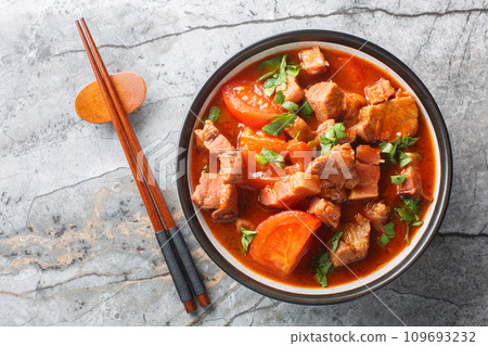 Indonesian stewed pork belly with tomatoes, onions, sweet soy sauce and Asian spices close-up in a bowl. Horizontal top view Indonesian stewed pork belly with tomatoes, onions, sweet soy sauce and Asian spices close-up in a bowl. Horizontal top view 109693232