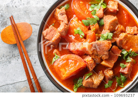Babi Tomat Pork belly stewed with tomatoes, onions, sweet soy sauce and spices close-up in a bowl. Horizontal top view 109693237