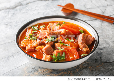 Spicy Pork Belly cooked with tomatoes, onions, sweet soy sauce and spices close-up in a bowl. Horizontal 109693239