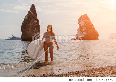 Woman sea sup. Close up portrait of happy young caucasian woman with long hair looking at camera and smiling. Cute woman portrait in bikini posing on sup board in the sea 109693560