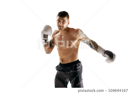 Young man, shirtless boxing athlete with muscular body training, punching isolated over white background Young man, shirtless boxing athlete with muscular body training, punching isolated over white background 109694167