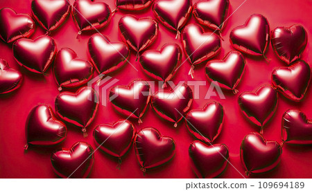 Red foil balloons in the shape of a heart on a red background. Valentine's Day Celebration, Birthday, Mother's Day 109694189