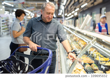 Man chooses ready meals in culinary department 109695832