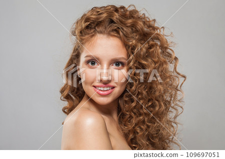 Smiling redhead woman fashion model with shiny curly brown hair and natural healthy fresh skin 109697051