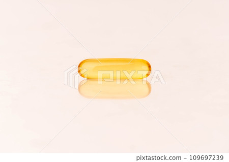 Close up of oil softgel capsules on white background with reflection. Nutritional supplement contains fish oil, omega 3, omega 6, omega 9, vitamin e, vitamin d and vitamin a. Selective focus. Close up of oil softgel capsules on white background with reflection. Nutritional supplement contains fish oil, omega 3, omega 6, omega 9, vitamin e, vitamin d and vitamin a. Selective focus. 109697239